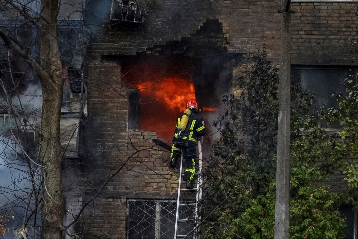 Firefighters work to put out a fire in a residential building hit by a Russian missile.