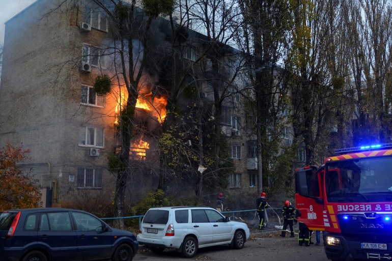 Firefighters work to put out a fire in a residential building hit by a Russian missile strike.