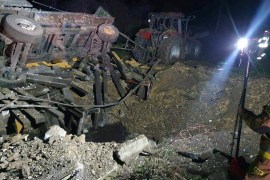 Rubble illuminated by lights after an explosion in a village in eastern Poland