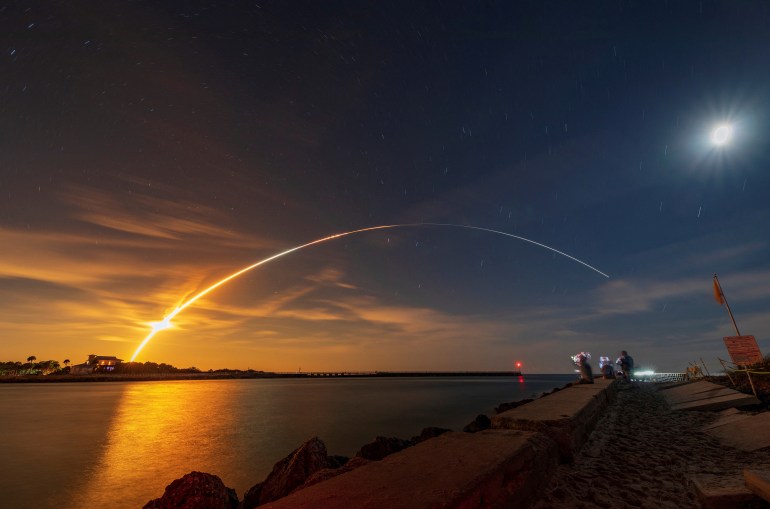 SLS Rocket arcs across the night sky as it launches from the Kennedy Space Center in Cape Canaveral, Florida