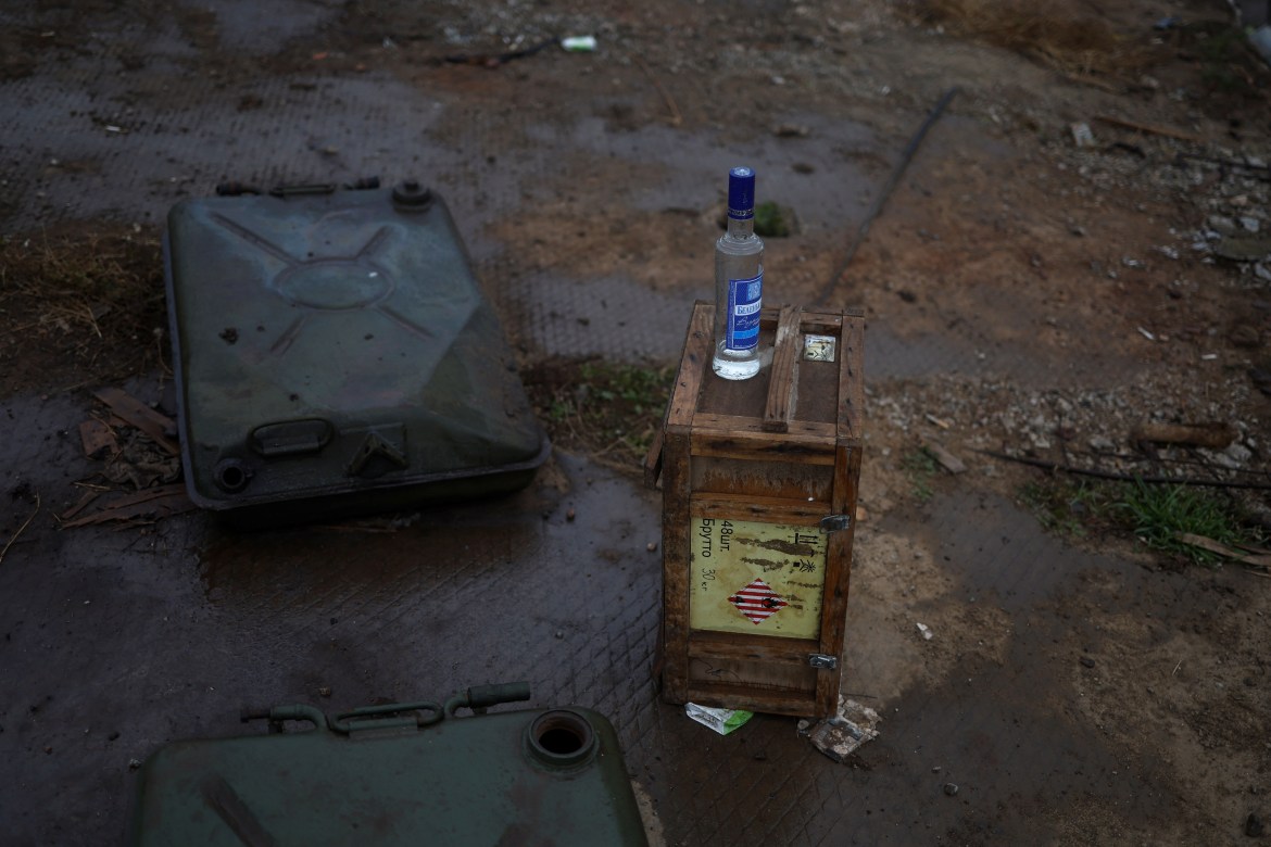 A bottle of vodka is seen at a former position of Russian soldiers at a compound