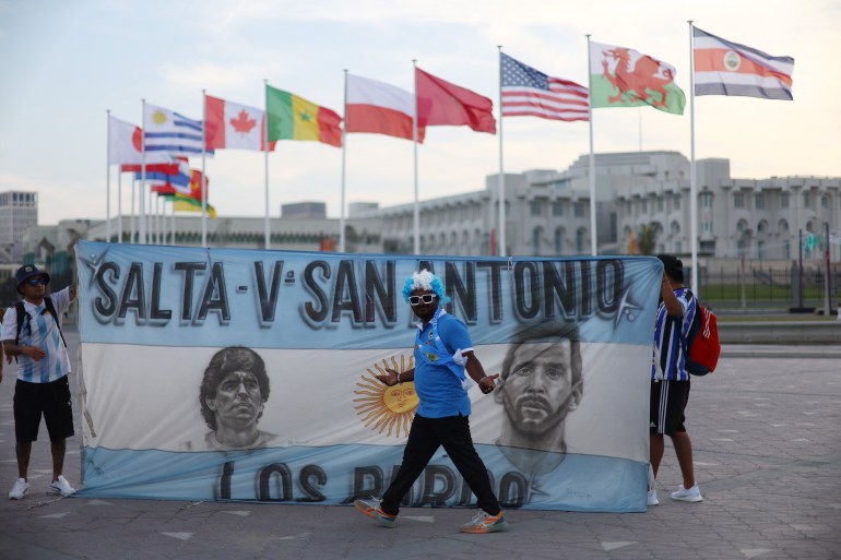 Football football - FIFA World Cup Qatar 2022 Preview, Doha, Qatar - 17 novembre 2022 Un fan argentin pose devant un drapeau de Lionel Messi argentin et de l'ancien joueur Diego Maradona REUTERS/Hannah Mckay