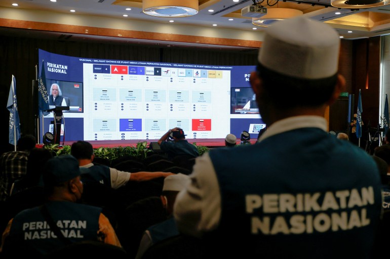 Apoiadores do Perikatan Nasional assistem a uma transmissão de vídeo dos resultados ao vivo da 15ª eleição geral da Malásia em um hotel em Shah Alam, Malásia