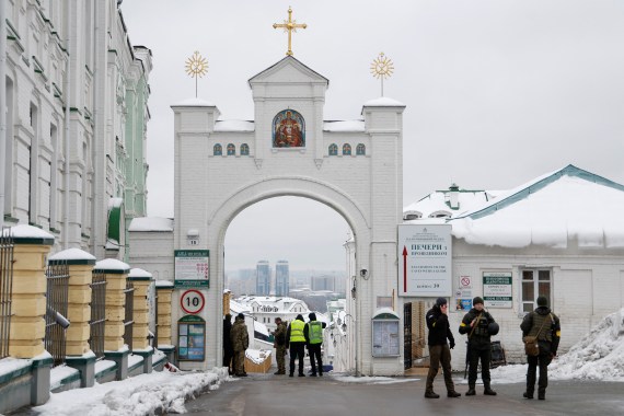A group of Ukrainian law enforcement officers standing at entrance to the Kyiv Pechersk Lavra monastery compound. There is snow on the ground.