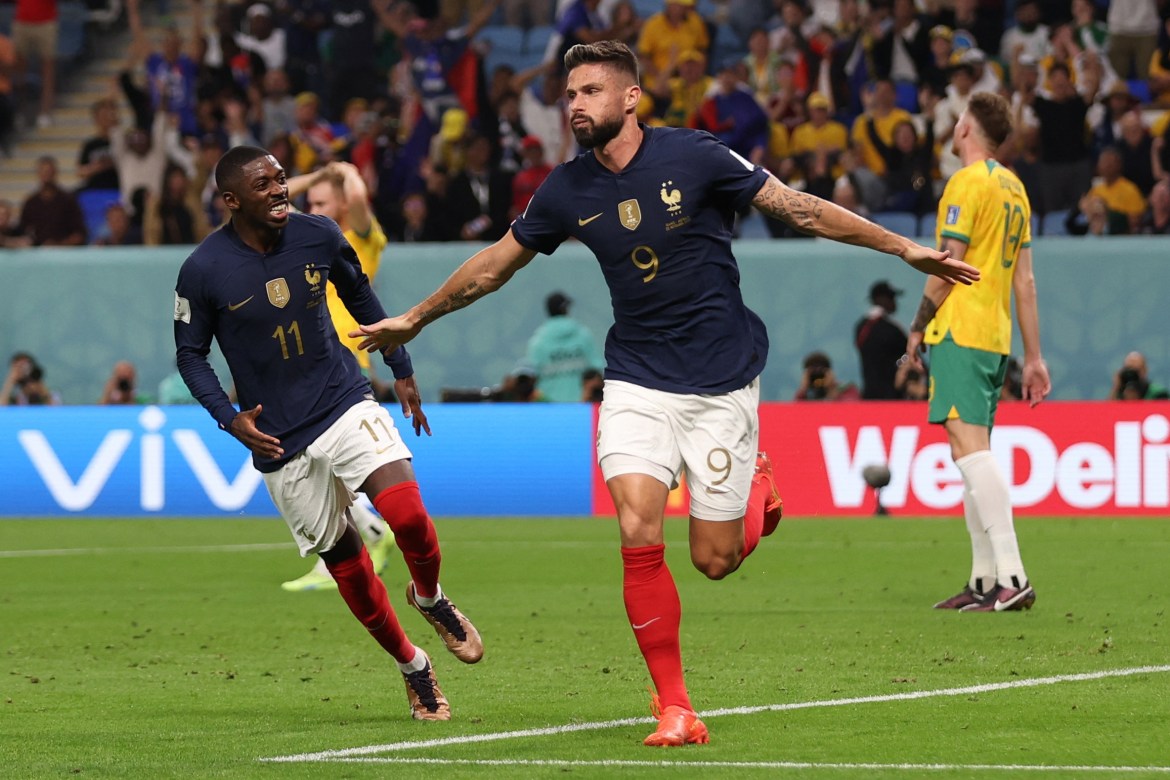 Dembele running next to Giroud and smiling at him, as Giroud runs with his arms out