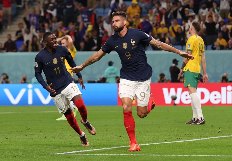 Dembele running next to Giroud and smiling at him, as Giroud runs with his arms out