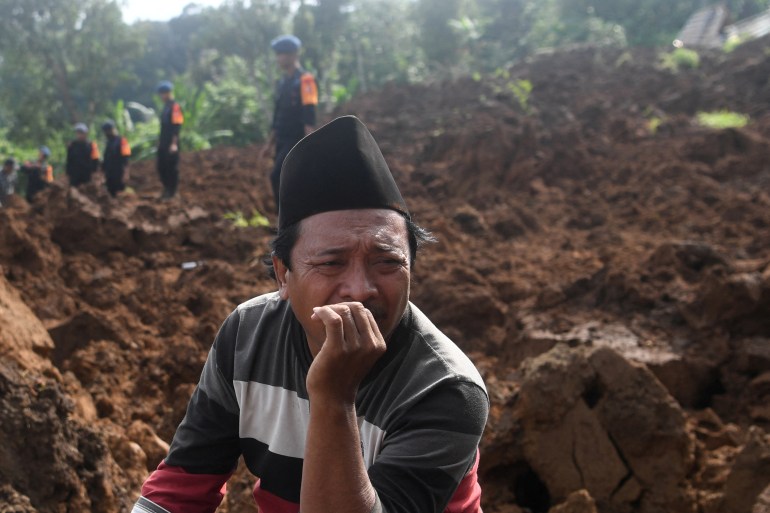 A traumatised relative as rescuers dig for survivors at the site of a landslide in West Java. He looks devastated