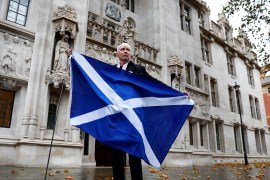 A pro-Scottish independence campaigner poses with a Scottish flag outside the United Kingdom Supreme Court in a case to decide whether the Scottish government can hold a second referendum on independence next year without approval from the British parliament