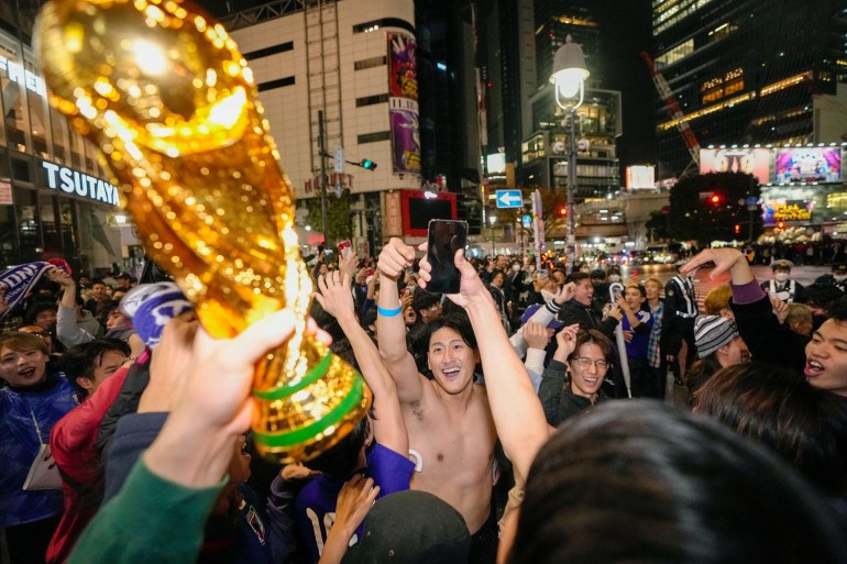Japanese soccer fans celebrate after Japan won a FIFA World Cup match against Germany