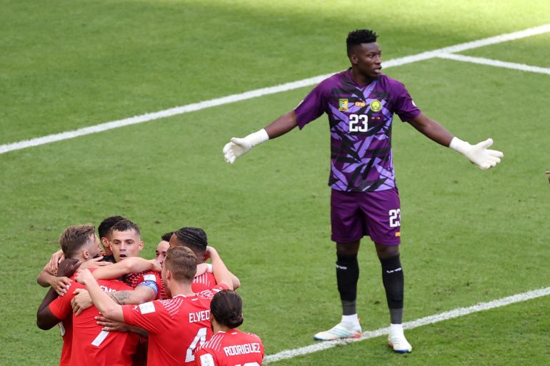 Switzerland's Breel Embolo celebrates scoring their first goal with teammates as Cameroon's Andre Onana reacts