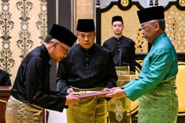 Malaysia's King Sultan Abdullah Sultan Ahmad Shah and Malaysia's newly appointed Prime Minister Anwar Ibrahim take part in the swearing-in ceremony at the National Palace in Kuala Lumpur