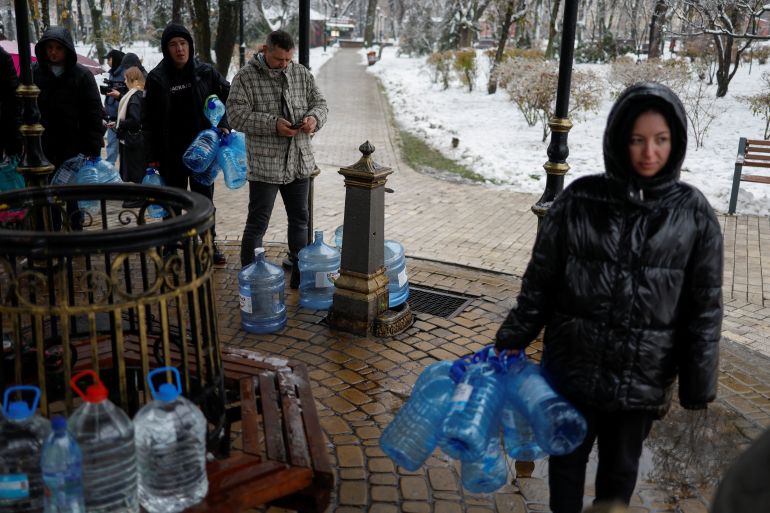 Residents fill up bottles with drinking water after critical civil infrastructure was hit by Russian missiles in Kyiv, Ukraine