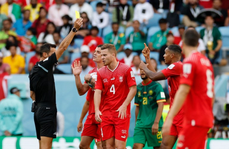 Switzerland's Manuel Akanji is shown a yellow card by referee Facundo