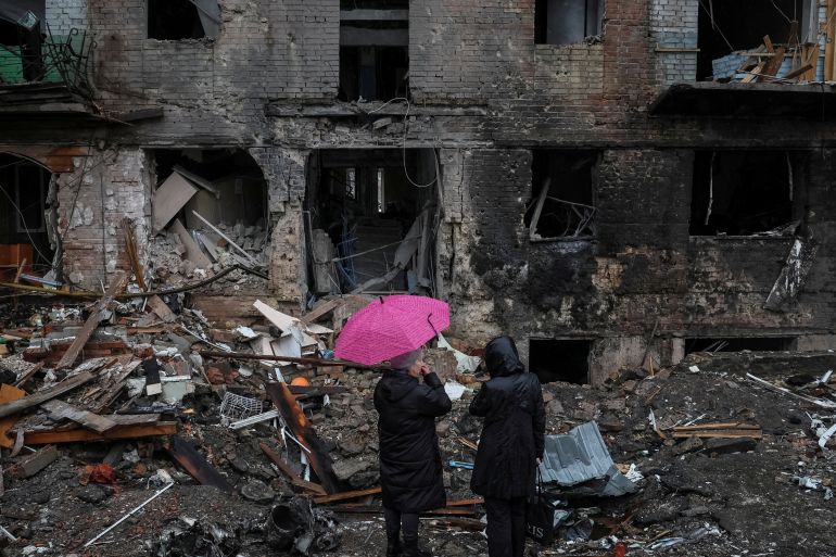 Residents stand near their building destroyed by a Russian missile attack in the town of Vyshhorod, near Kyiv, Ukraine.