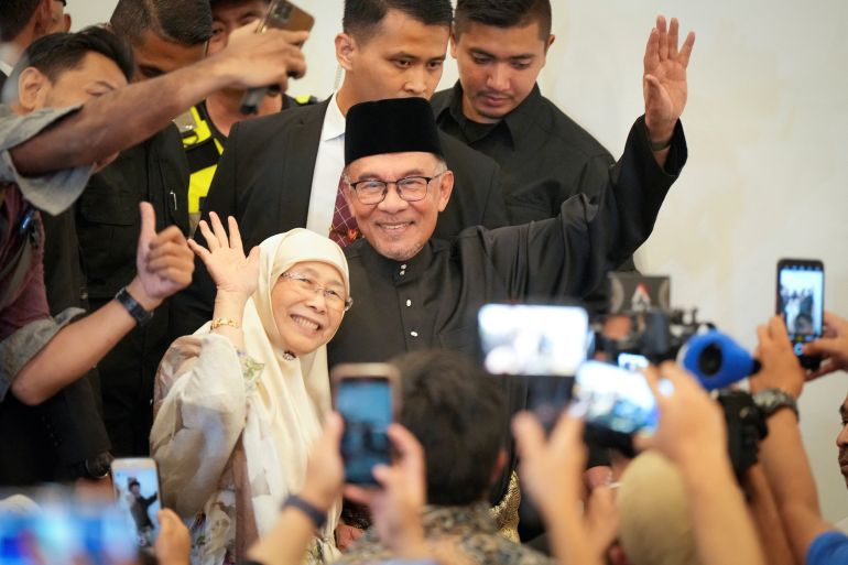 Malaysia's newly appointed Prime Minister Anwar Ibrahim and his wife Wan Azizah wave as they arrive at a gathering in Kuala Lumpur, Malaysia