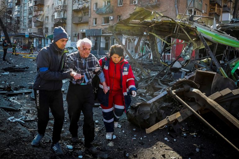 Medics help a wounded resident of a house destroyed by shelling in Kyiv