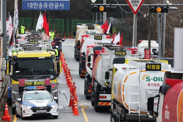 Tankers drive past other tankers taking part in a strike by a truckers' union in Sungnam, South Korea.