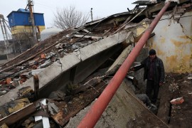 Two workers dig out a tractor tire from the rubble of a destroyed storage building at a grain processing centre even as their town continues to take incoming shelling in Siversk, Donetsk region, Ukraine.