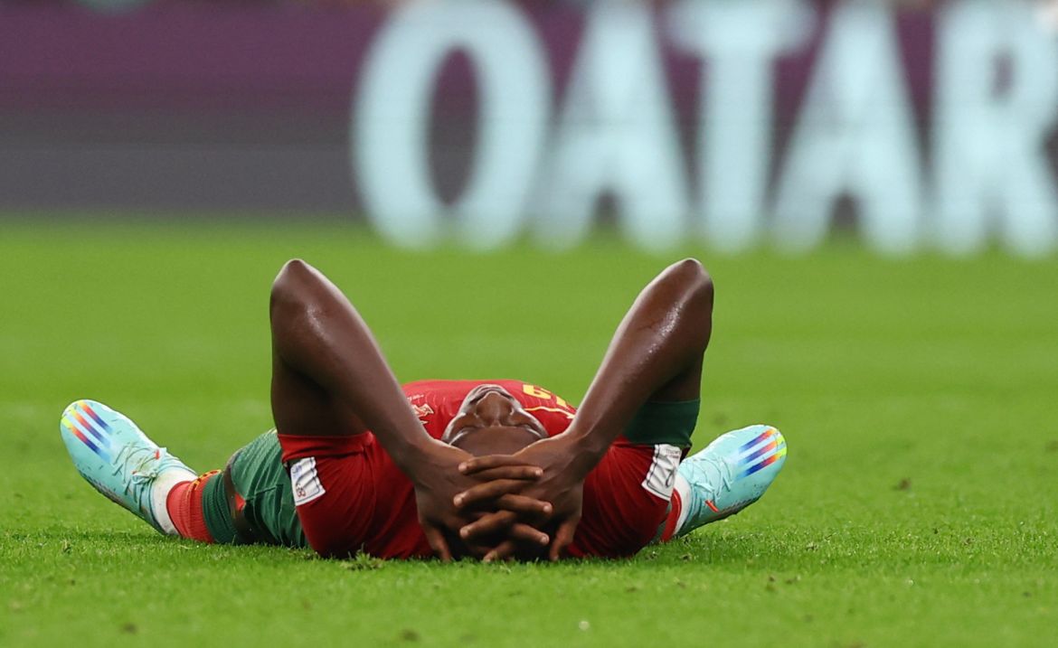 Portugal's Nuno Mendes goes down during the match. He is seen lying on his back and grabbing his head.