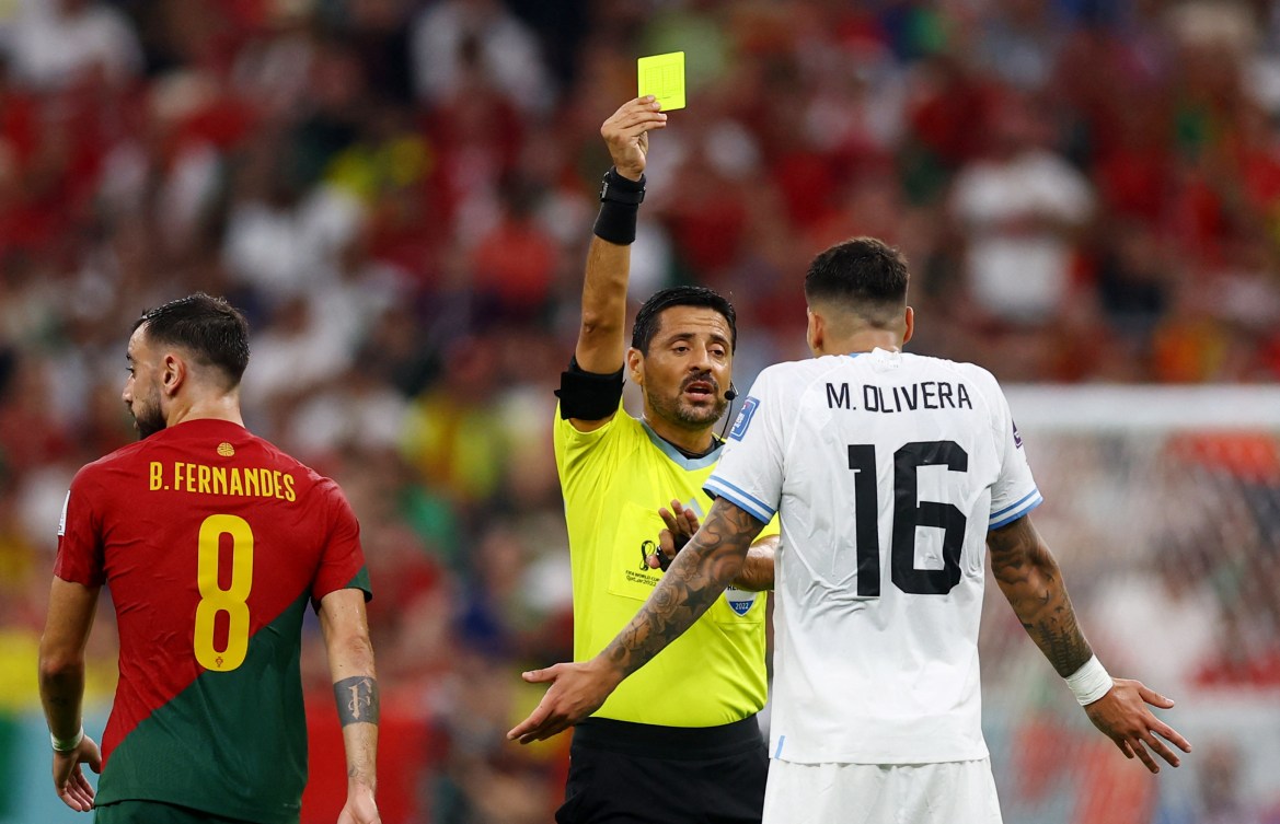 Mathias Olivera is shown a yellow card by referee Alireza Faghani.