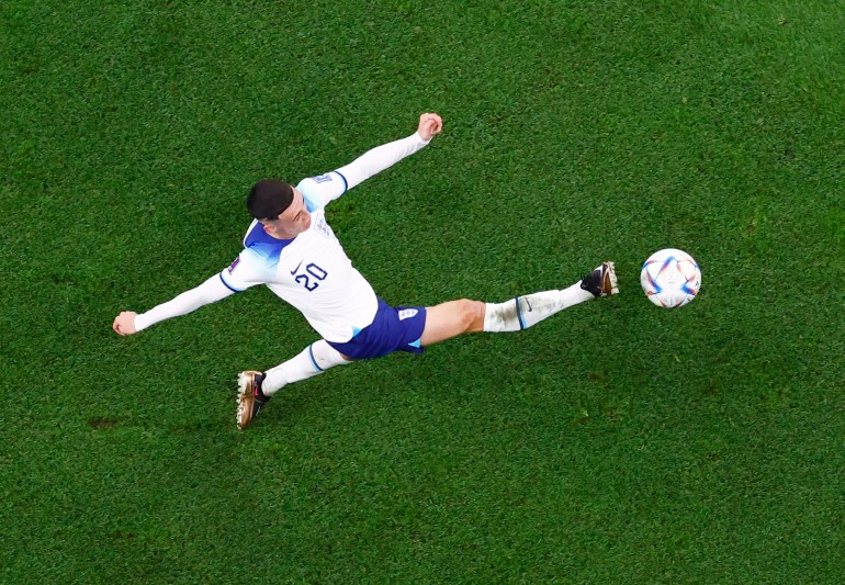 View from the top shows Foden in the centre, surrounded by the green of the pitch, with arms outstretched and a straight, right foot kicking the ball