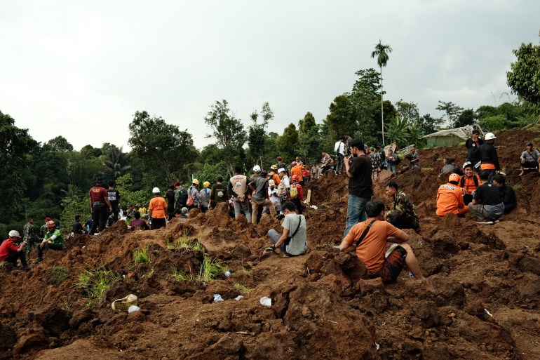 Rescue workers and local people dig through the brown mud to try and find survivors after Monday's earthquake unleashed devastating landslides