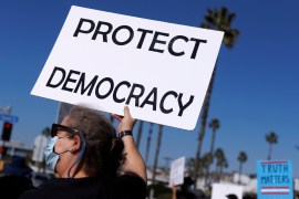 A person holds a sign that reads Protect Democracy