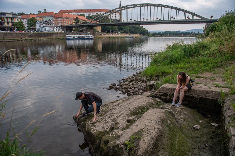 People look at Hunger Stones on the bank of the Elbe, Czech Republic.