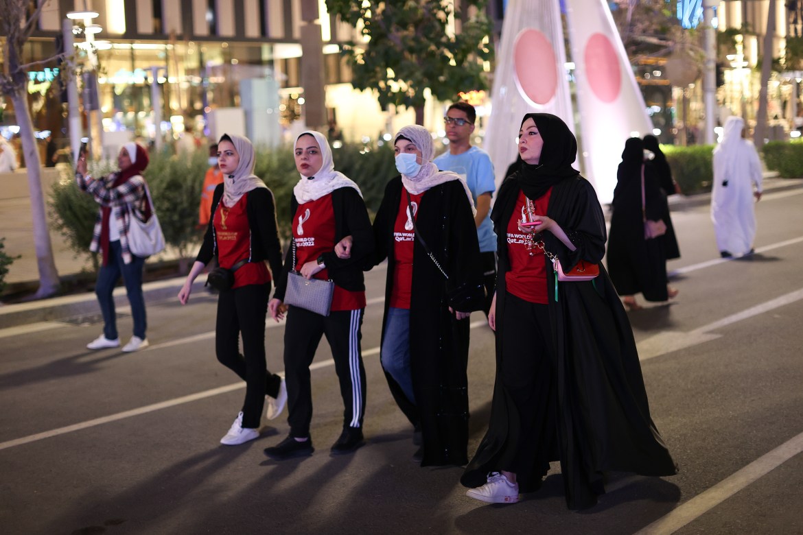 A group of women walk down the street.