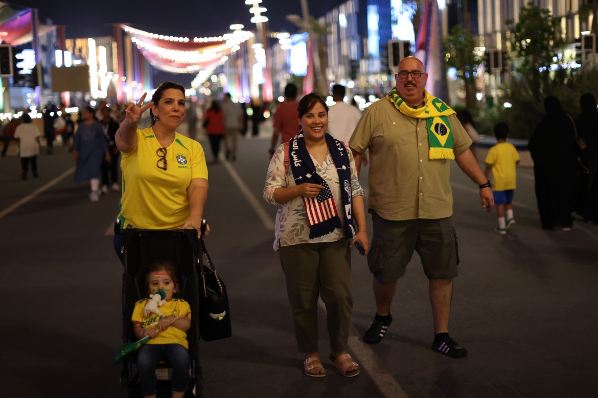People walking down the road at night during festivities prior to the beginning of the FIFA World Cup.