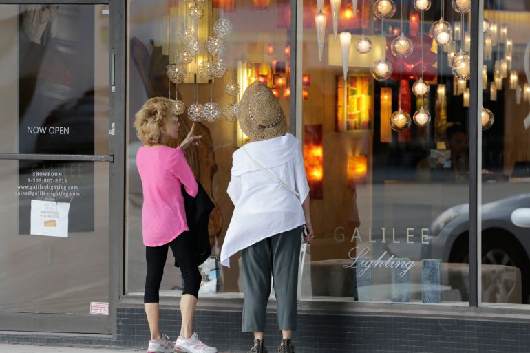 shoppers stop to look in the window of a lighting store in the Design District of Miami Beach, Florida in US