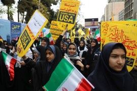 Schoolgirls hold national flags along with anti-US placards at the annual rally in front of the former US Embassy in Tehran, Iran on November 4, 2019 - the 40th anniversary of the 1979 student takeover of the US Embassy in Tehran and the 444-day hostage crisis that followed [File: Vahid Salemi/AP]