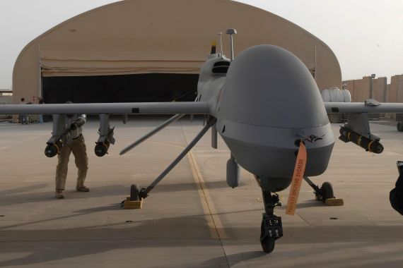 In this image provided by the US Army, contractors from General Atomics load Hellfire missiles onto an MQ-1C Gray Eagle drone.