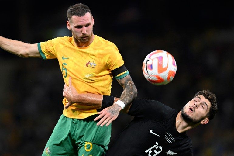 Australia's Martin Boyle, left, and New Zealand's Liberato Cacace compete for a high ball during a friendly soccer international in Brisbane, Australia, Thursday, Sept. 22, 2022. (AP Photo/Dan Peled)