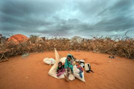 A Somali woman and child wait to be given a spot to settle at a camp for displaced people