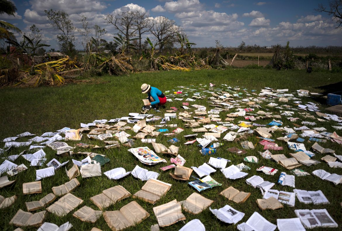 A teacher dries out books at a school that was heavily damaged by Hurricane
