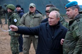 Russian President Vladimir Putin gestures as he visits a military training centre of the Western Military District in Russia with Deputy Commander of the Airborne Troops Anatoly Kontsevoy.