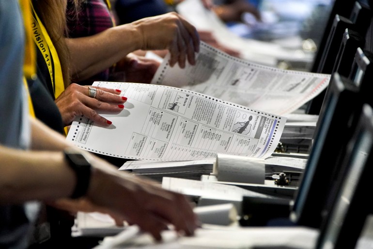 Hands of election workers and ballot papers during a recount in the US