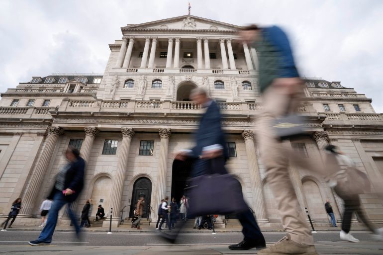 People pass the Bank of England in London