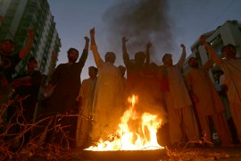 Supporters of former Pakistani Prime Minister Imran Khan's party, Pakistan Tehreek-e-Insaf, chant slogans next to a burning tire during a protest to condemn a shooting incident on their leader's convoy, in Karachi, Pakistan, Thursday, Nov. 3, 2022. A gunman opened fire Thursday at a campaign truck carrying Khan, wounding him slightly in the leg and killing one of his supporters, his party and police said. Nine others were also wounded. (AP Photo/Fareed Khan)