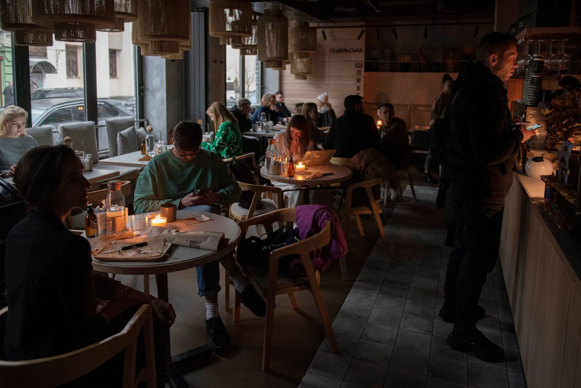 People sit in a cafe during a blackout in Kyiv.