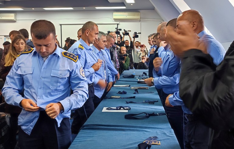 Kosovalı Sırp polis memurları Kosova'nın Zvecan kasabasında üniformalarını çıkarıyor.