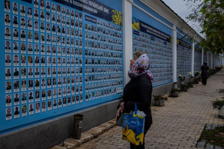 A woman stands in front of the "Memory wall of fallen defenders of Ukraine in Russia-Ukranian war" in downtown Kyiv, Ukraine, Monday, Nov. 7, 2022. (AP Photo/Bernat Armangue)