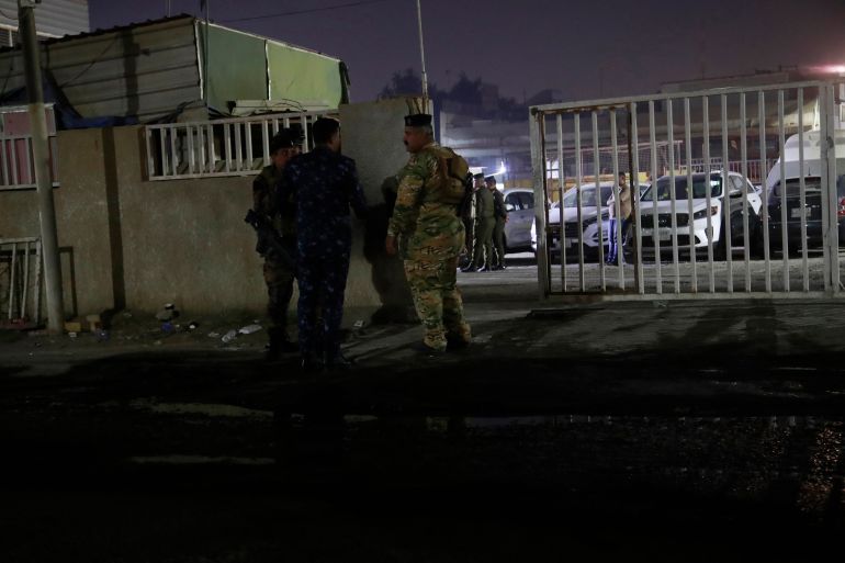 Iraqi security forces gather outside a morgue