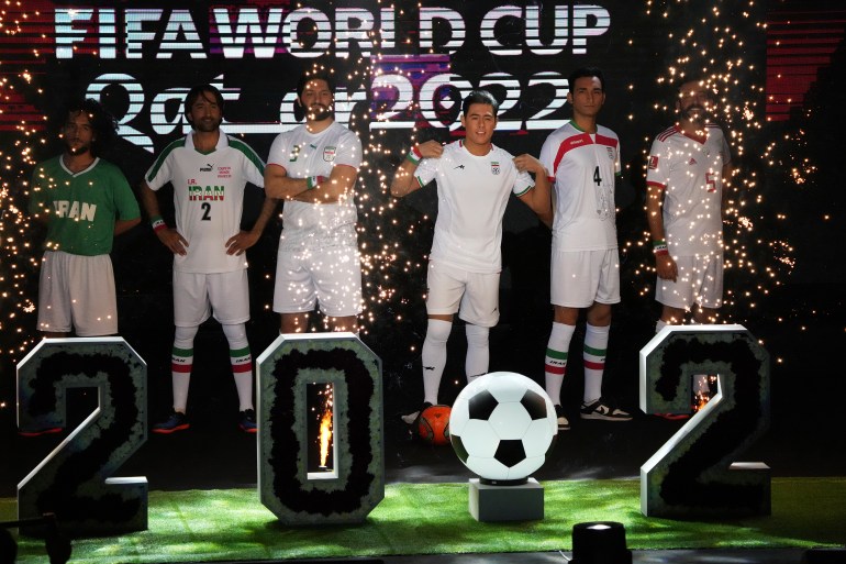 A model wears the Iranian national football team's new kit, third right, for the upcoming 2022 World Cup