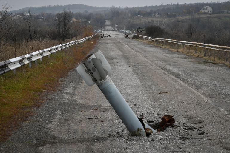 A tail of a multiple rocket sticks out of the ground near the recently recaptured village of Zakitne, Ukraine