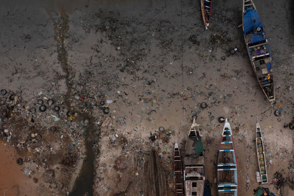Open sewage flows to the ocean next to traditional boats known as pirogues at the Yarakh Beach in Dakar, Senegal.