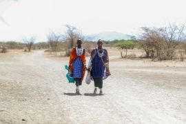 Two Maasai women walk back home from a market in Ol Kiramatian, near Lake Magadi, in Kenya.