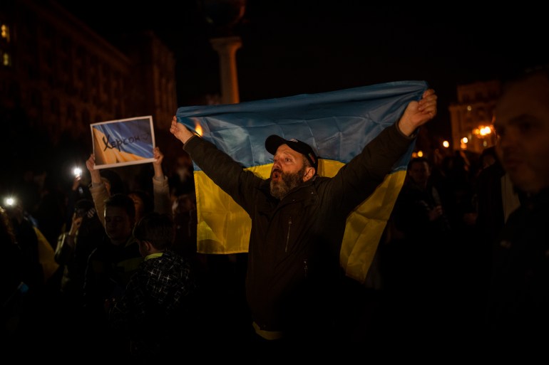 Ukrainians gather in central Kyiv to celebrate the recapturing of Kherson city, Ukraine, Friday, Nov. 11, 2022. (AP Photo/Bernat Armangue)