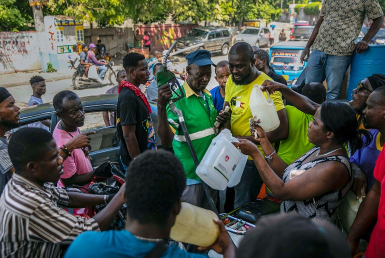 People crowd around a gas pump in Port-au-Prince, Haiti